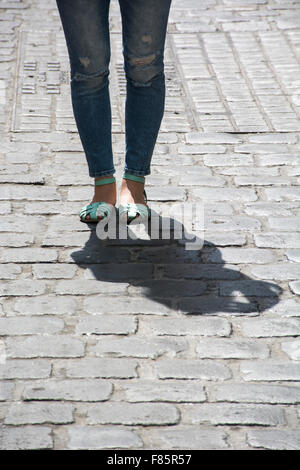 Giovane donna in piedi su una strada basolata Foto Stock