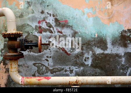 Metallo angolato tubo con valvola contro la coloratissima parete di pelatura a Baku, in Azerbaijan Foto Stock
