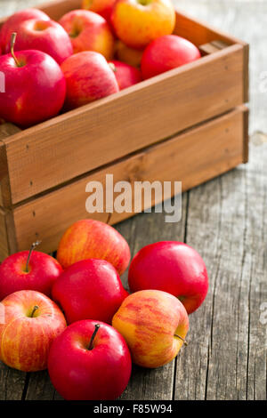 Autunno rosso mele sul vecchio tavolo in legno Foto Stock