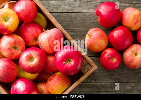 Autunno rosso mele sul vecchio tavolo in legno Foto Stock