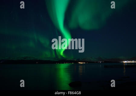 Incredibile forte aurora boreale sul fiordo e montagna innevata Foto Stock