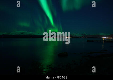 Incredibile forte aurora boreale sul fiordo e montagna innevata Foto Stock
