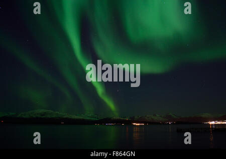 Incredibile forte aurora boreale sul fiordo e montagna innevata Foto Stock