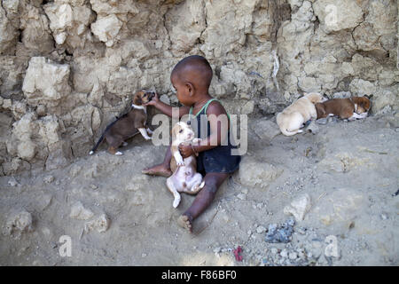 Nov. 29, 2015 - Cox's Bazar, Bangladesh - Cox's Bazar, BANGLADESH - 29 novembre: Achild giocando con il cane i bambini a Kutubdia isola il 29 novembre 2015.Kutubdia, un isola a Cox's Bazar costa. le avversità di natura principalmente indotta dal cambiamento climatico. Durante gli ultimi due decenni gli impatti del clima in Bangladesh sono stati accellerating.Kutubdia è anche colpito duramente. Il posto è molto vulnerabile ai cicloni e mareggiate, che sono diventati più frequenti e intense in Bangladesh nonché innalzamento del livello del mare e le onde più forte. Il risultato è la massiccia erosione e salininty intrusione, n. Foto Stock