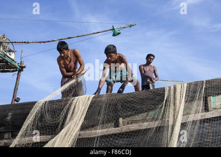 Nov. 29, 2015 - Cox's Bazar, Bangladesh - Cox's Bazar, BANGLADESH - Novembre 29:Fisher uomo del cambiamento climatico e del livello del mare area di sollevamento a riparare le net per la pesca in mare nei pressi di Kutubdia Islandof Cox's Bazar Dstrict il 29 novembre 2015...Kutubdia, un isola a Cox's Bazar costa. le avversità di natura principalmente indotta dal cambiamento climatico. Durante gli ultimi due decenni gli impatti del clima in Bangladesh sono stati accellerating.Kutubdia è anche colpito duramente. Il posto è molto vulnerabile ai cicloni e mareggiate, che sono diventati più frequenti e intense in Bangladesh nonché in aumento Foto Stock