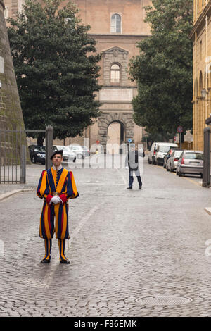 Città del Vaticano, il Vaticano. 06 Dic, 2015. L'ingresso principale in Vaticano è sempre protetto da una guardia svizzera. - Le forze di sicurezza prima della inaugurazione del Giubileo in San Pietro. La maggior parte degli uomini della sicurezza sono identificabili in mezzo alla folla Credito: Francesco Gustincich/Alamy Live News Foto Stock
