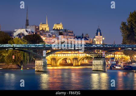 Pont des Arts, Pont Neuf, Notre Dame de Paris torri della cattedrale e il fiume Senna. Illuminata vista serale. Ile de la Cite, Parigi Foto Stock