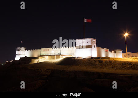 Riffa storico Fort illuminata di notte. Regno del Bahrein, Medio Oriente Foto Stock