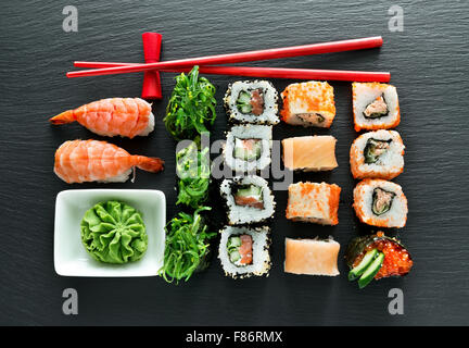 Set di sushi con wasabi e bastoncini su lavagna Foto Stock
