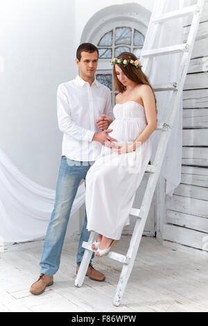 Allegro coppia giovane vestito di bianco in piedi a casa Foto Stock