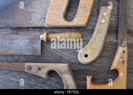 Impugnature in legno di vecchie seghe / old handsaws dettagli su sfondo di legno Foto Stock