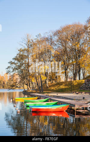 Colorate barche a remi ormeggiate sul lago con riflessi e colori autunnali, Lago di Galve, Trakai, una città storica e resort in Lituania Foto Stock