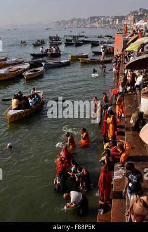 Devoti Indù pregare in ginocchio profondo ganga acqua a Ghat di Varanasi. Varanasi è la seconda città più antica del mondo, situato a Foto Stock