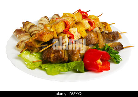 Spiedini di pollo, maiale manzo, agnello con verdi sulla piastra, isolato su sfondo bianco Foto Stock