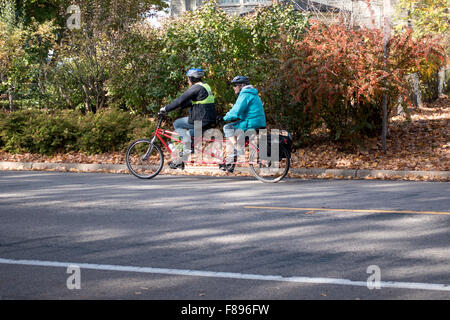 Due vecchi signori su biciclette tandem costruita per due con negozi di generi alimentari nella sacca a nord del fiume Mississippi Boulevard St Paul Minnesota MN USA Foto Stock