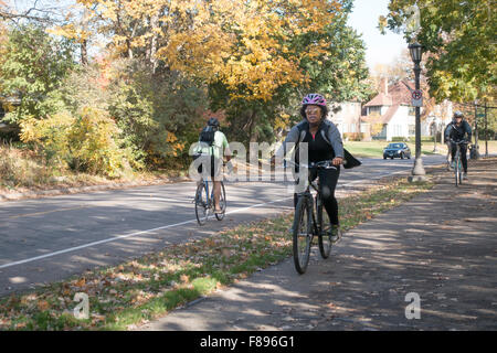 Bicyclers indossare i caschi utilizzando sia su strada e sentiero. A nord del fiume Mississippi Boulevard St Paul Minnesota MN USA Foto Stock