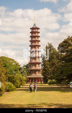 Vista di due persone che camminano verso la pagoda giapponese in Kew Gardens, Londra in una giornata di sole in estate Foto Stock