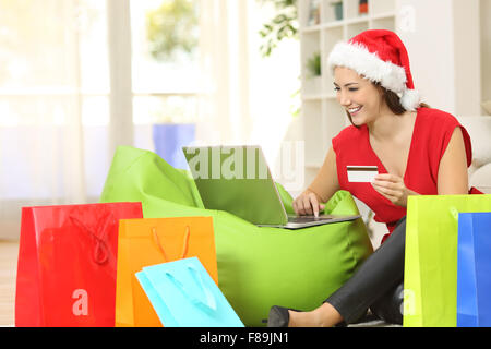 Moda Donna acquisto online per natale seduto sul pavimento con colorati borse per lo shopping a casa Foto Stock