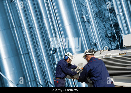 Il petrolio e il gas lavoratori nella parte anteriore delle tubazioni gigante Foto Stock