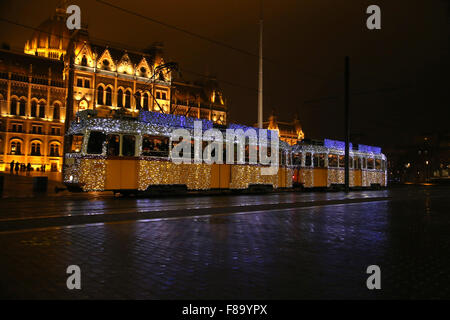 Persone non identificate che viaggiano sul Natale speciale tram con luci festose in Budapest Ungheria Foto Stock