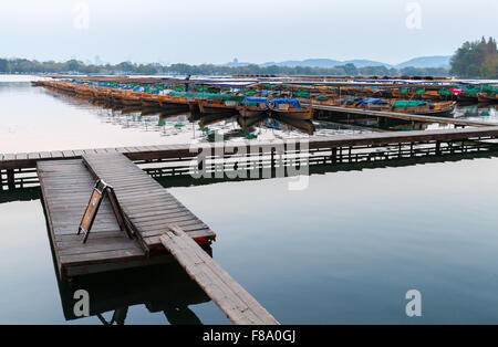 Hangzhou, Cina - 4 Dicembre 2014: Cinese tradizionale in legno barche di ricreazione galleggianti ormeggiate sul Lago Ovest, famoso parco in H Foto Stock