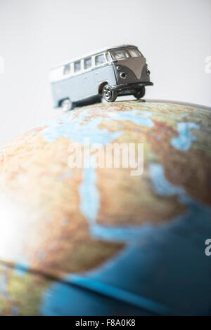 Vintage bus VW sul globo terrestre. Concetto in miniatura Foto Stock