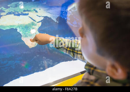 Bambino rivolto verso l Africa su una mappa. Foto Stock