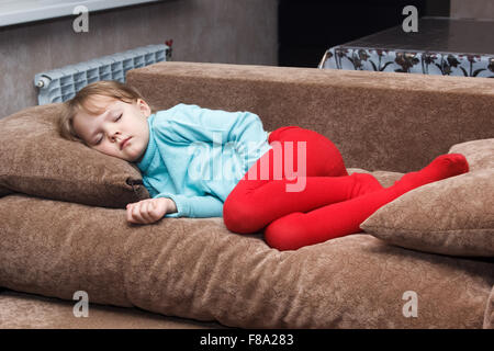 Piccola ragazza dorme come una parte superiore su un lettino Foto Stock