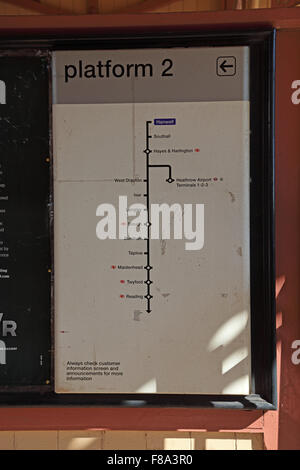 Un abbastanza vecchia piattaforma metallica board sulla piattaforma che mostra la destinazione dei treni da quella piattaforma. Foto Stock