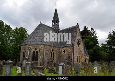 La chiesa in stile vittoriano a Luss vicino al Loch lomond insieme all'interno di area boschiva con cimitero Foto Stock