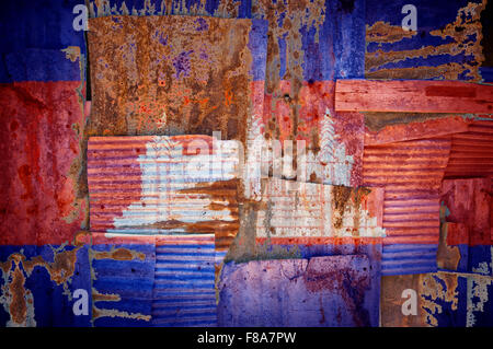 Un abstract immagine di sfondo della bandiera della Cambogia dipinta su di rusty ferro corrugato fogli sovrapposti per formare una parete Foto Stock