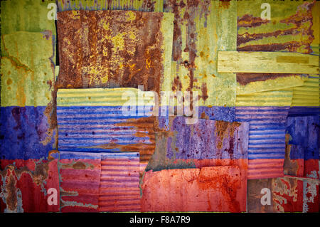 Un abstract immagine di sfondo di bandiera della Colombia dipinta su di rusty ferro corrugato fogli sovrapposti per formare una parete Foto Stock