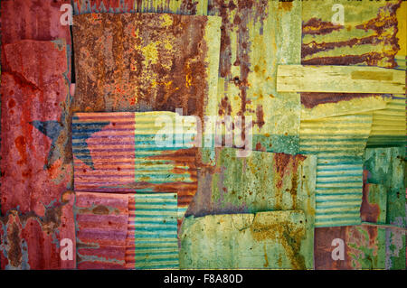 Un abstract immagine di sfondo della bandiera della Guinea Bissau dipinta su di rusty ferro corrugato fogli sovrapposti per formare una parete Foto Stock