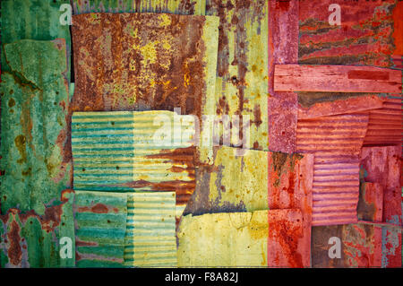 Un abstract immagine di sfondo di bandiera del Mali dipinta su di rusty ferro corrugato fogli sovrapposti per formare una parete di recinzione o. Foto Stock