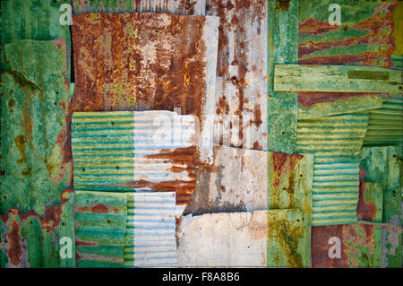 Un abstract immagine di sfondo della bandiera della Nigeria dipinta su di rusty ferro corrugato fogli sovrapposti per formare una parete Foto Stock