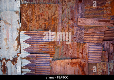 Un abstract immagine di sfondo di bandiera del Qatar dipinta su di rusty ferro corrugato fogli sovrapposti per formare una parete di recinzione o Foto Stock