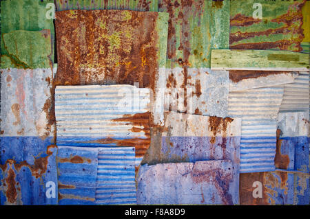 Un abstract immagine di sfondo della bandiera della Sierra Leone dipinta su di rusty ferro corrugato fogli sovrapposti per formare una parete Foto Stock