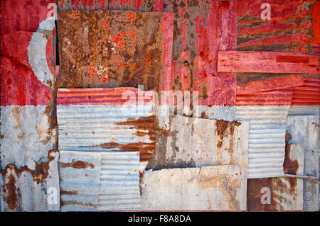 Un abstract immagine di sfondo della bandiera di Singapore dipinta su di rusty ferro corrugato fogli sovrapposti per formare una parete Foto Stock