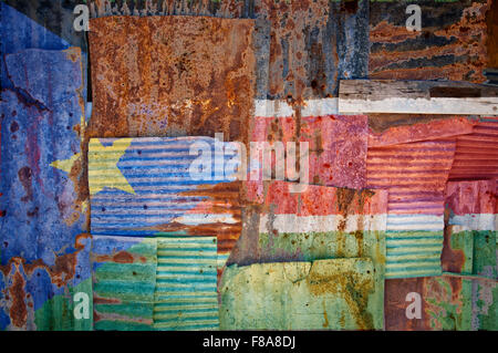 Un abstract immagine di sfondo di bandiera del sud Sudan dipinta su di rusty ferro corrugato fogli sovrapposti per formare una parete Foto Stock