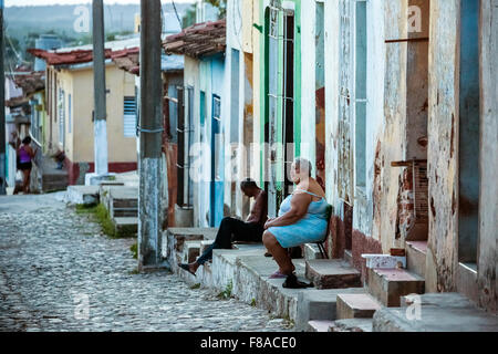 I cubani seduti sui suoi passi davanti le loro case nel vecchio, grasso donna, uomo vecchio, scene di strada nella città vecchia di Trinidad, Foto Stock