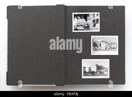 Aprire vintage photo album con la pagina vuota e vecchie foto in bianco e nero Foto Stock