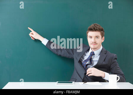 Ritratto di imprenditore puntando con il dito indice e fissando sulla parte anteriore Foto Stock