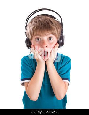 Ritratto di giovane ragazzo in ascolto di musica sulle cuffie contro uno sfondo bianco Foto Stock
