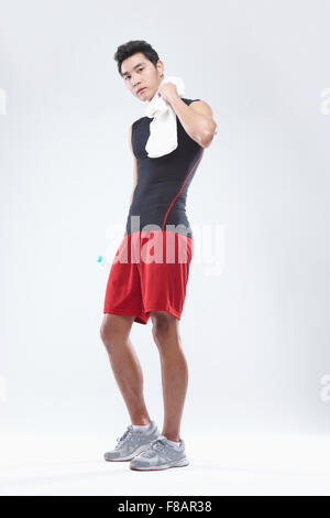 Uomo in sportswear tergi sudore con waterbottle in mano lo sguardo sul lato anteriore Foto Stock