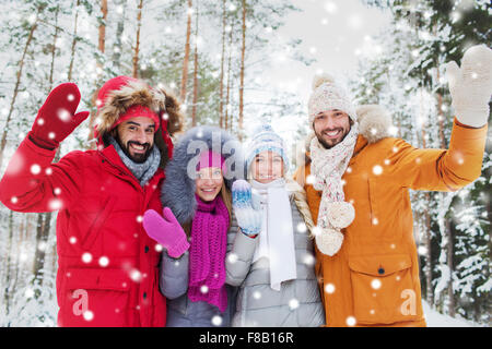 Gruppo di amici sventolando le mani nella foresta di inverno Foto Stock