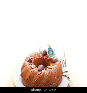 Torta di Natale ciambella con albero come decorazione di festa sulla parte superiore su sfondo bianco Foto Stock