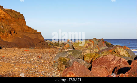 Una vista delle scogliere di erosione e rock corazza mare difese a Happisburgh, Norfolk, Inghilterra, Regno Unito. Foto Stock