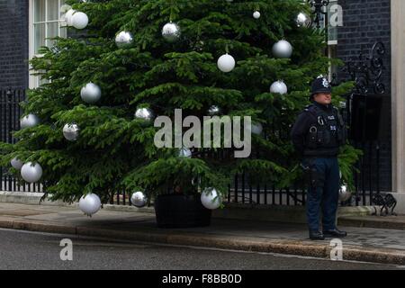 Un poliziotto si distingue per l'albero di Natale al di fuori del numero dieci di Downing Street. Foto Stock