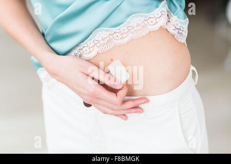 Donna di applicare una patch. Foto Stock