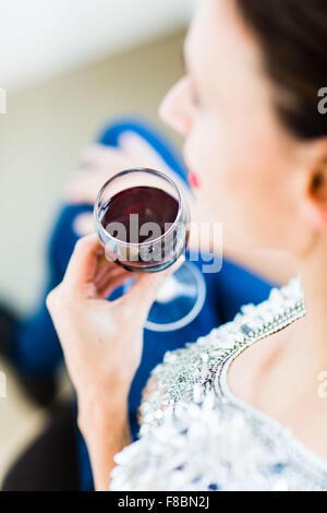 Donna di bere un bicchiere di vino rosso. Foto Stock